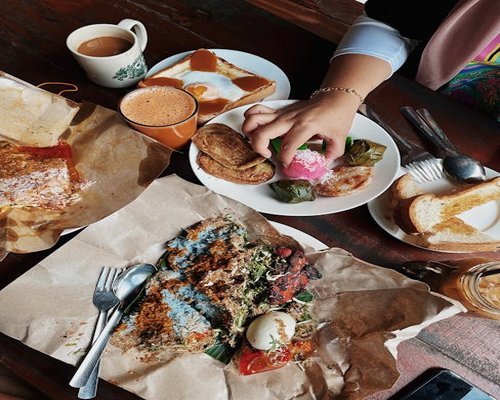 Suasana pagi dengan sarapan lokal di meja kayu